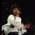 Mick Jagger of the Rolling Stones holds a microphone to his face while performing
