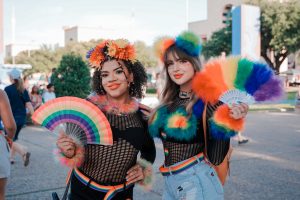 Two people in colorful rainbow outfits